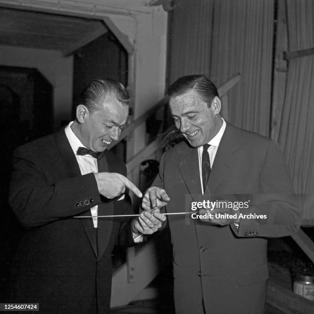 Zwei Männer spielen mit einem Dirigentenstab in Hamburg, Deutschland 1950er Jahre.