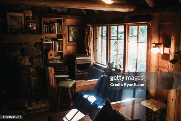 sunlight streams in rustic cabin window in the forest - rustic cabin stock pictures, royalty-free photos & images