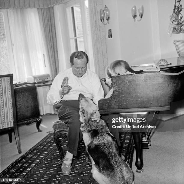 Der deutsche Komponist, Produzent und Schlagersänger Hans Arno Simon mit seinem Wellensittich, seiner Katze und seinem Hund in Hamburg, Deutschland...
