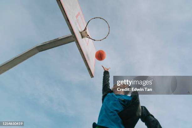 an asian chinese senior man practicing basket ball game in the basket ball court in the morning - old basketball hoop stock pictures, royalty-free photos & images