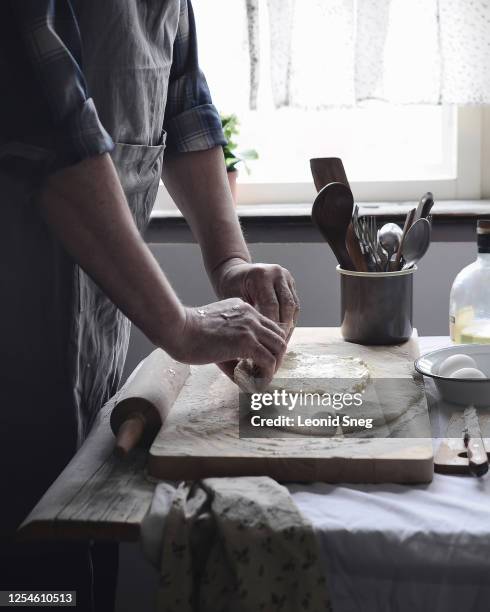 caucasian man farmer hands cooking food, roll out the dough on a table side view in a provencal style kitchen - butter tart stock pictures, royalty-free photos & images