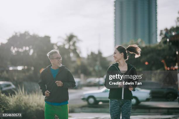 an asian chinese senior man warm up exercise before playing basket ball game in the basket ball court in the morning with his daughter - running coach stock pictures, royalty-free photos & images