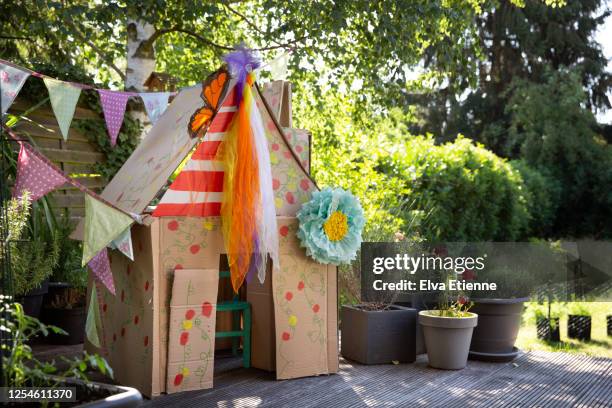 a child's colourful homemade playhouse in a back yard made from recycled cardboard boxes - playhouse stock-fotos und bilder