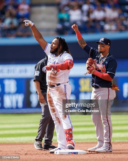 Vladimir Guerrero Jr. #27 of the Toronto Blue Jays reacts as he takes second base in front of Orlando Arcia of the Atlanta Braves in the fourth...