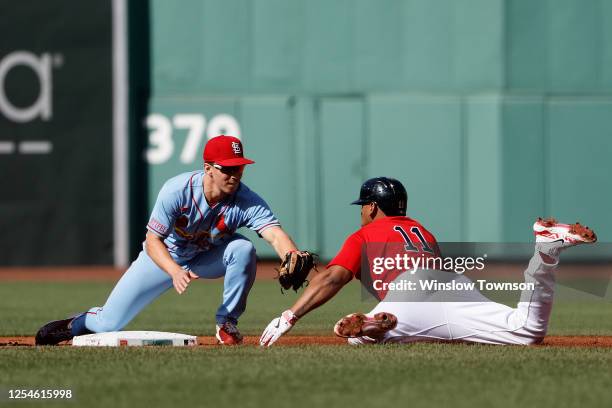 Tommy Edman of the St. Louis Cardinals tags out Rafael Devers of the Boston Red Sox trying to stretch an RBI single into a double during the first...