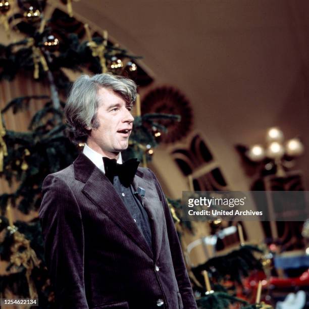 Der niederländische Showmaster Rudi Carrell unterm Weihnachtsbaum, Deutschland 1970er Jahre.