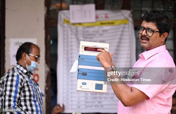 Election staff members open an electronic voting machine to count votes for the result of Local bodies' election inside a vote counting center at...