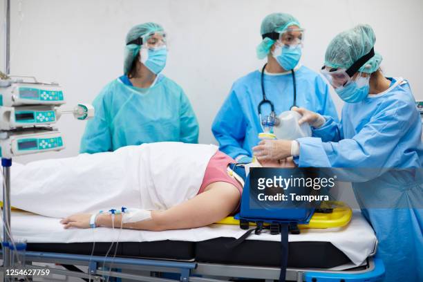 nurses using a manual ventilator on a covid patient. - patient on ventilator stock pictures, royalty-free photos & images