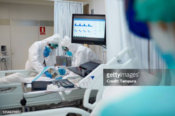 healthcare workers during an intubation procedure to a covid patient - state of emergency stock pictures, royalty-free photos & images