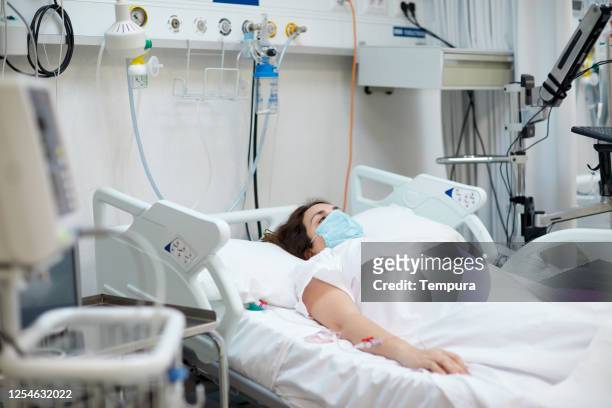 hospital covid patient with an oxygen mask lying down in bed. - patient lying down stock pictures, royalty-free photos & images