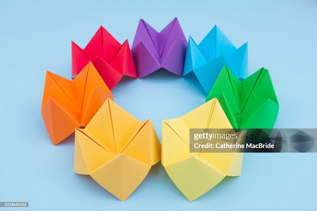 Paper Fortune Tellers arranged by colour on a blue background