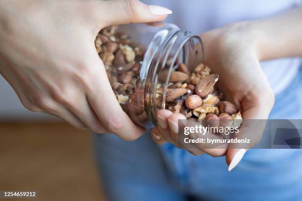 nuts in woman hands - healthy fats stock pictures, royalty-free photos & images