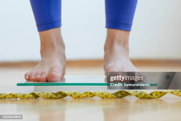 pieds femelles sur l’échelle de pesage - anorexie nerveuse photos et images de collection