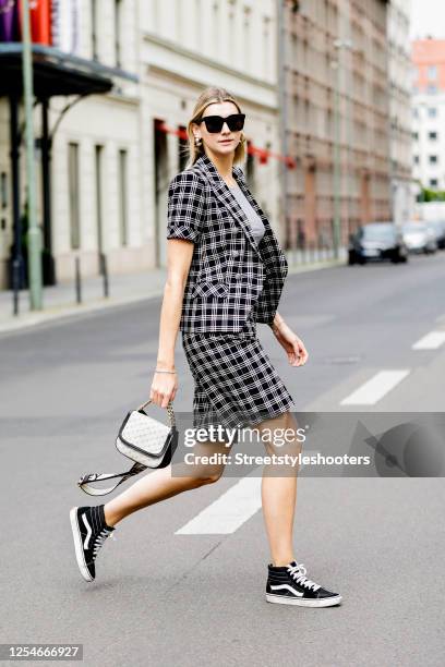 Influencer Kimyana Hachmann wearing a black and white checked short suit by Veronica Beard, a grey shirt by Grey Fashion Berlin, a bag by Stella...