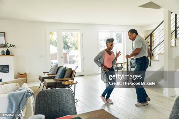 mature couple dancing in living room - wide shot of people stock pictures, royalty-free photos & images
