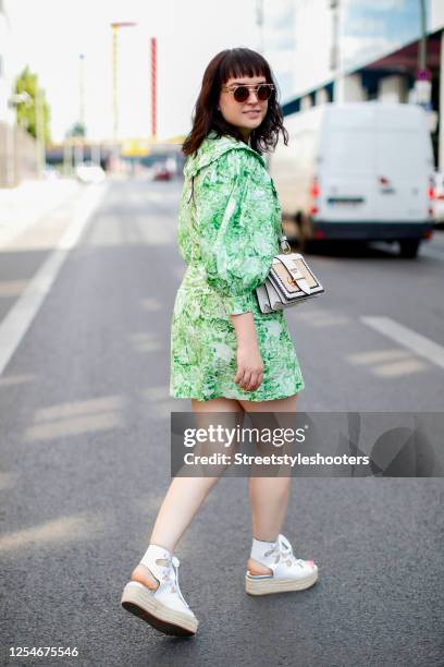 Author, TV host and influencer Vreni Frost wearing a green patterned dress by Ganni, a bag by Prada, white plateau shoes by Miu Miu and sunglasses by...