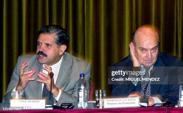 Former Argentinean Economy Minister Ricardo Lopez Murphy and present title holder Domingo Cavallo talk to assistants during a seminar of the Central...