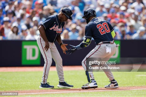 Marcell Ozuna of the Atlanta Braves celebrates a two-run home run against the Toronto Blue Jays with Ron Washington during second inning of their MLB...