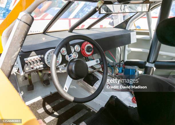 An interior view of the Pontiac car showing the steering wheel, accelerator and brake pedals, and dashboard controls, as seen during practice for...