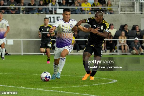 Darlington Nagbe of the Columbus Crew and Cesar Araujo of Orlando City SC battle for the ball during the second half at Lower.com Field in Columbus,...