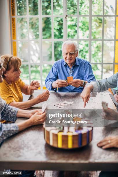 senior friends having fun playing cards - retirement card stock pictures, royalty-free photos & images