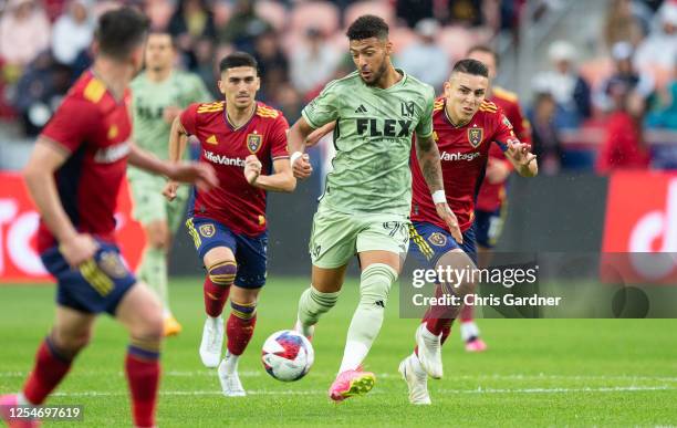 Denis Bouanga of the Los Angeles FC rushes the ball up field against Bryan Oviedo and Pablo Ruiz of Real Salt Lake during the second half of their...