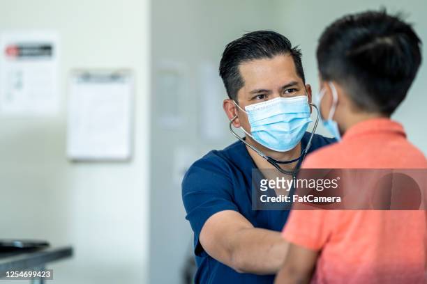 jonge jongen bij een artsenbenoeming die een masker draagt. - jaarlijks evenement stockfoto's en -beelden