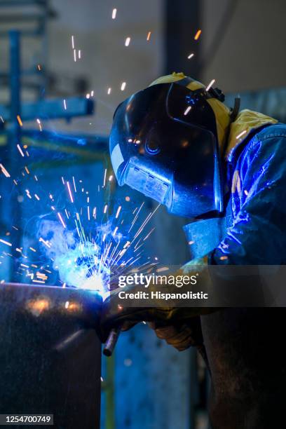 soudeur méconnaissable travaillant dans une usine portant des vêtements de travail protecteurs - welder photos et images de collection