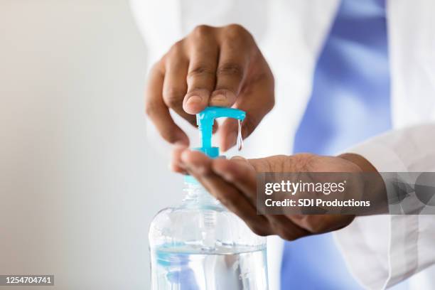 female doctor uses hand santizer - washing hands close up stock pictures, royalty-free photos & images