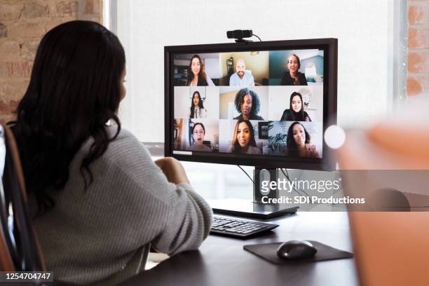 businesswoman meets with colleagues during virtual staff meeting - desktop pc stock pictures, royalty-free photos & images