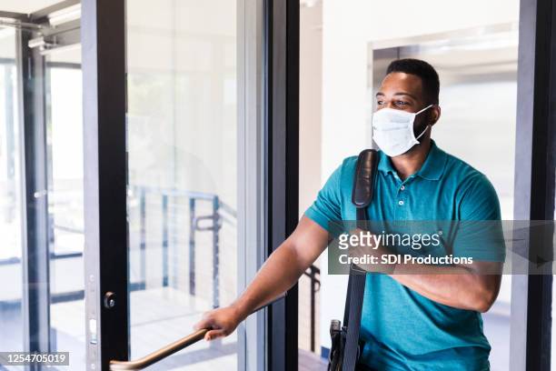 mid adult man arriving at work during covid-19 - arrival stock pictures, royalty-free photos & images