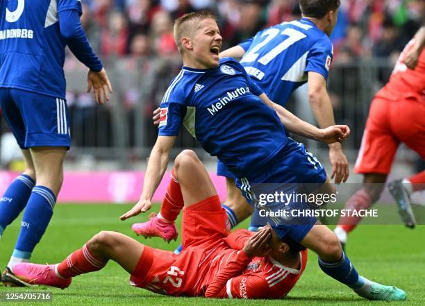 Schalke's Finnish defender Jere Uronen falls next to Bayern Munich's midfielder Jamal Musiala during the German first division Bundesliga football...