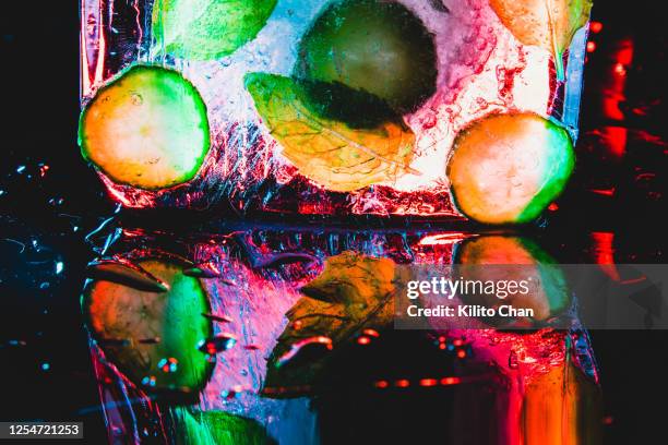 frozen ice block with fresh mint leaves and fruits in it - hard liquor stock pictures, royalty-free photos & images