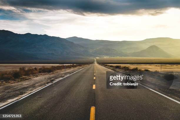 desert highway death valley - straßenverkehr stock-fotos und bilder