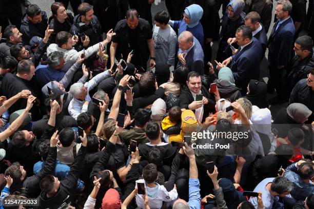 Turkish President Tayyip Erdogan and his wife Emine Erdogan meet supporters outside a polling station in the Uskudar district after casting their...