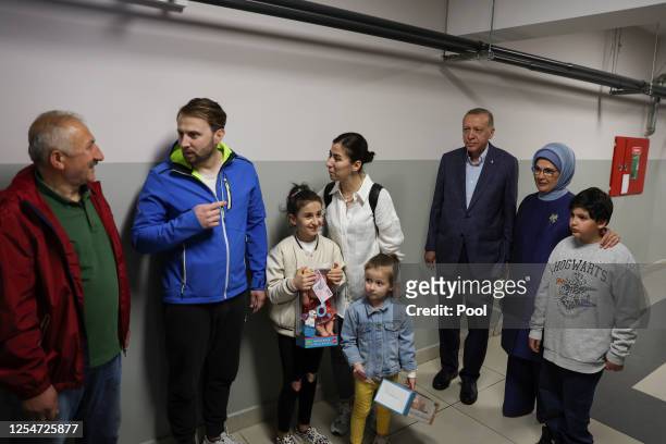 Turkish President Recep Tayyip Erdogan and his wife Emine Erdogan wait in line to cast their vote in Turkey's general election at a polling station...