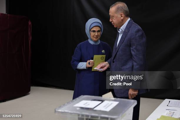 Turkish President Recep Tayyip Erdogan and his wife Emine Erdogan arrive to cast their vote in Turkey's general election at a polling station in the...