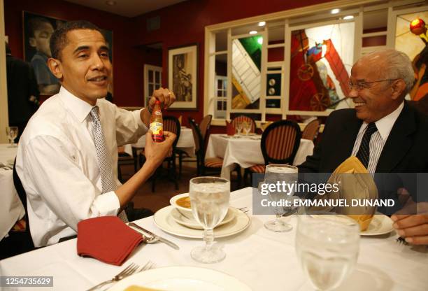 Democratic presidential candidate Illinois Senator Barack Obama holds a bottle of chili sauce while eating gumbo with Chairman of Louisiana Recovery...