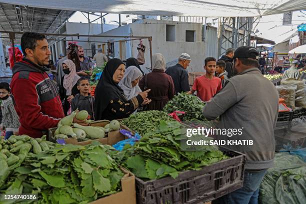 Palestinians shop at a market in Rafah in the southern Gaza Strip on May 14 amid a ceasefire ending five days of deadly fighting between Israel and...