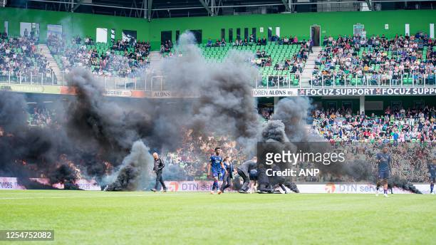 Groningen supporters throw fireworks on the pitch during the Dutch premier league match between FC Groningen and Ajax at the Euroborg stadium on May...