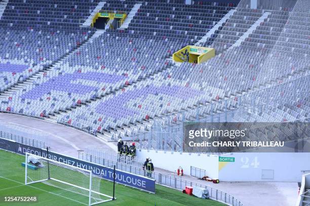 French firefighters operate in the stadium for a "security operation" delaying the start of the match, prior to the French L1 football match between...