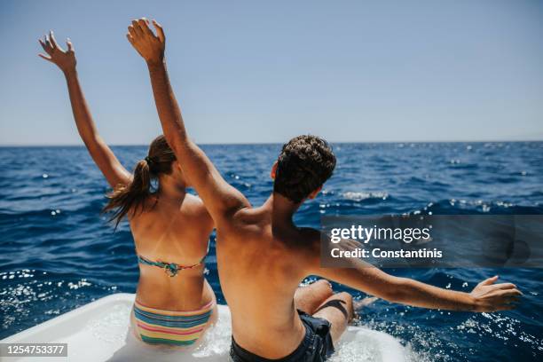 pareja joven divirtiéndose en el barco - small boat ocean fotografías e imágenes de stock