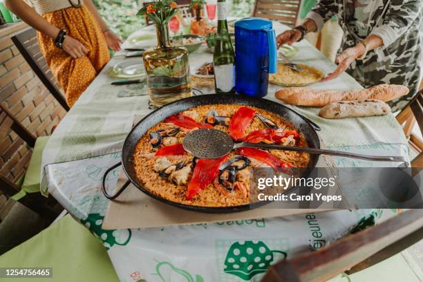 family serving paella in a familiar  reunion at home - carol cook stock pictures, royalty-free photos & images