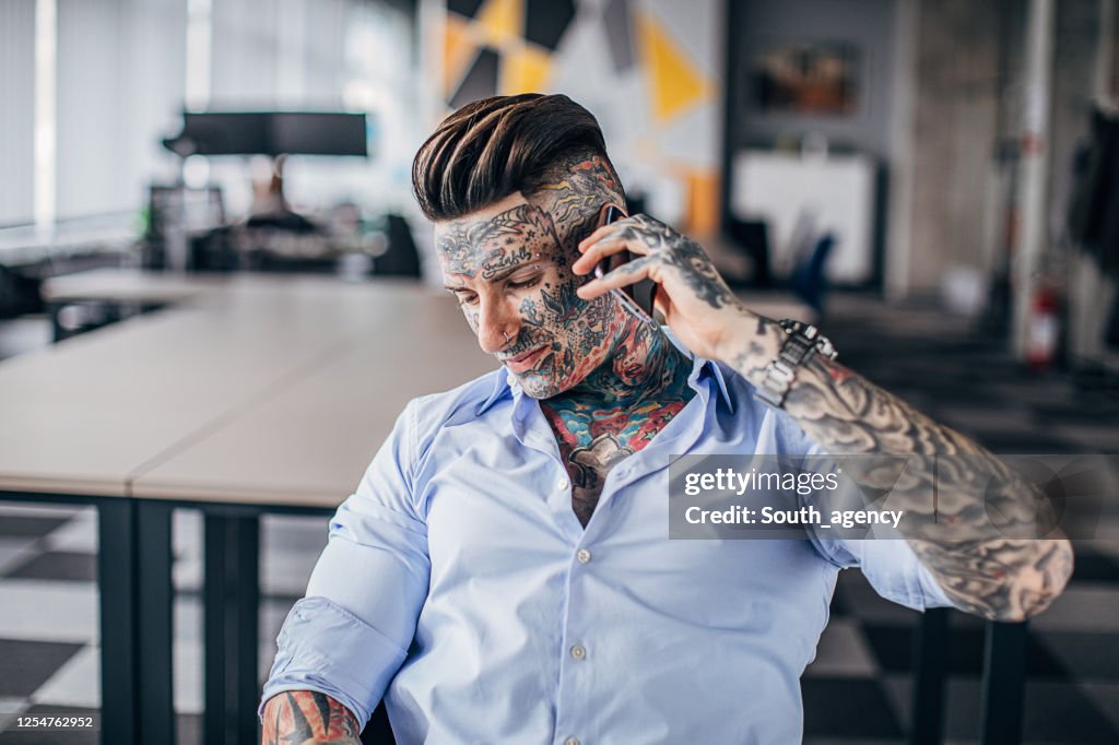 Modern Tattooed Businessman Using Smart Phone In Office High-Res Stock Photo - Getty Images Modern Tattooed Businessman Using Smart Phone In Office High-Res Stock Photo - Getty Images