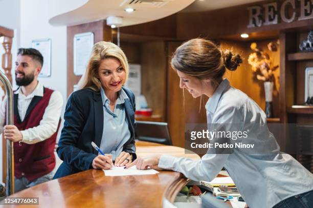 woman checking in at the hotel - door attendant stock pictures, royalty-free photos & images