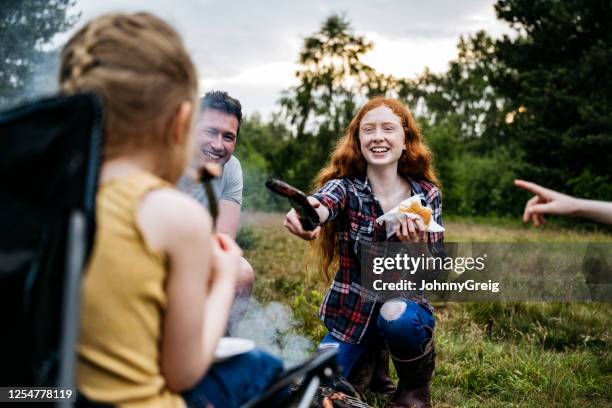 teenager-mädchen bietet junge schwester verbrannt wurst beim kochen - subjektive kamera ungewöhnliche ansicht stock-fotos und bilder