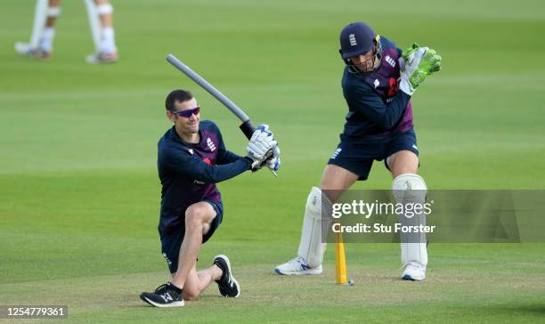 England wicketkeeper Jos Buttler takes part in a drill with coach Chris Read during a nets session at Ageas Bowl on July 07, 2020 in Southampton,...