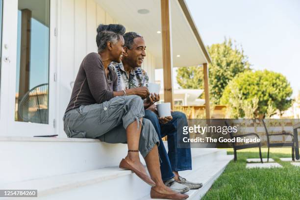 mature couple drinking coffee on porch - veranda fotografías e imágenes de stock