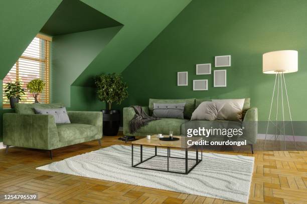 grünes wohnzimmer mit grünem sofa, couchtischen und pflanzen - color image stock-fotos und bilder