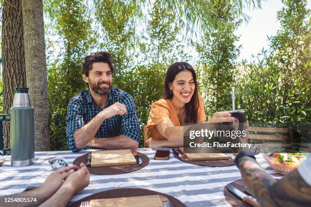 joyful young woman taking a drink from her brother on a family meeting - mate argentina stock pictures, royalty-free photos & images